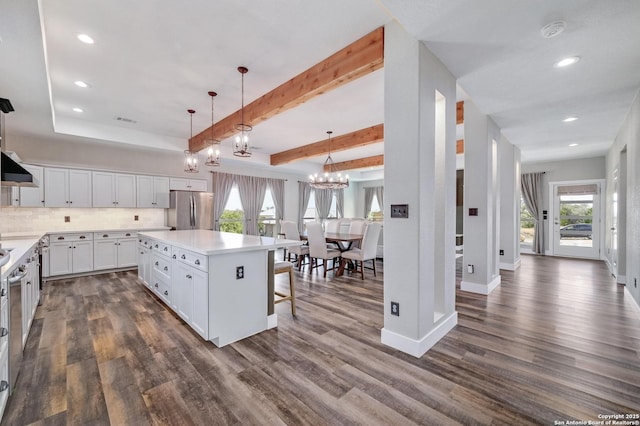 kitchen with dark wood-style floors, visible vents, freestanding refrigerator, and white cabinets