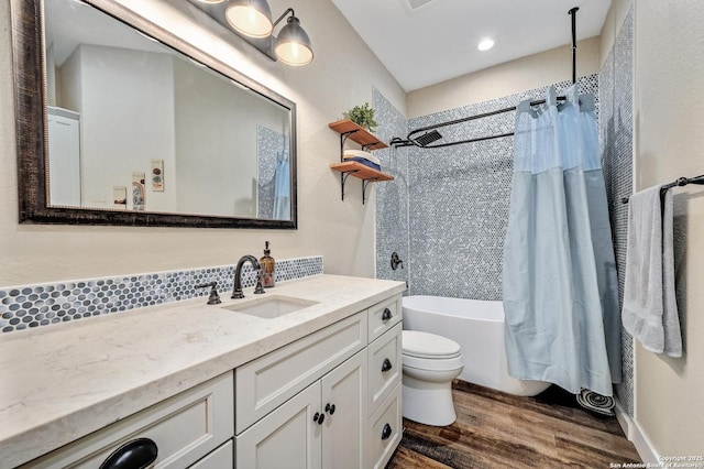 full bathroom featuring toilet, vanity, wood finished floors, and shower / tub combo with curtain