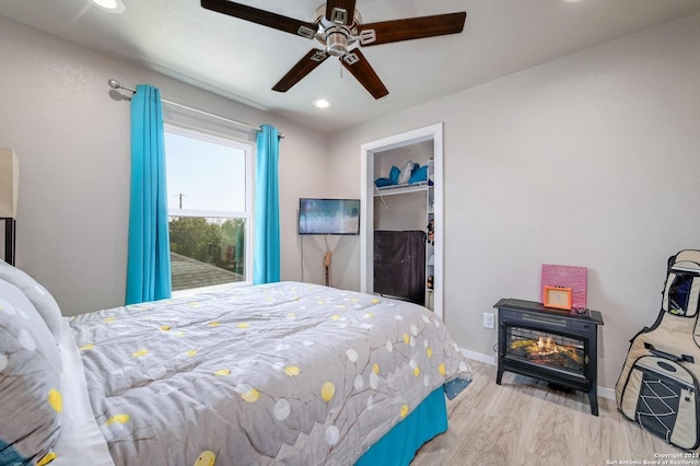 bedroom featuring recessed lighting, wood finished floors, a ceiling fan, baseboards, and a closet