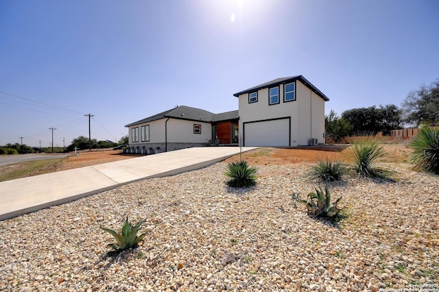 modern home featuring driveway, an attached garage, and stucco siding