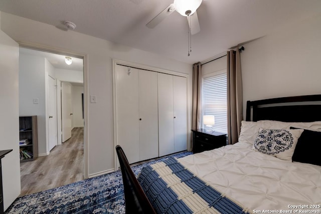 bedroom with a ceiling fan, a closet, and wood finished floors