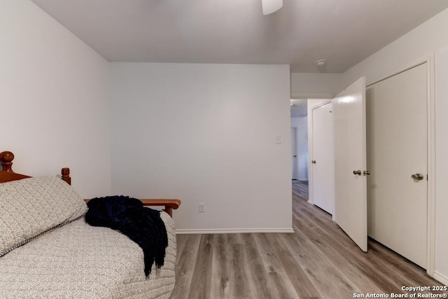 bedroom with ceiling fan, baseboards, and wood finished floors