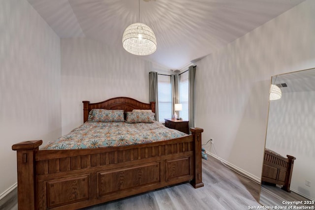 bedroom with vaulted ceiling and light wood-style flooring