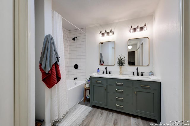 bathroom with a sink, double vanity, shower / bath combination with curtain, and wood finished floors