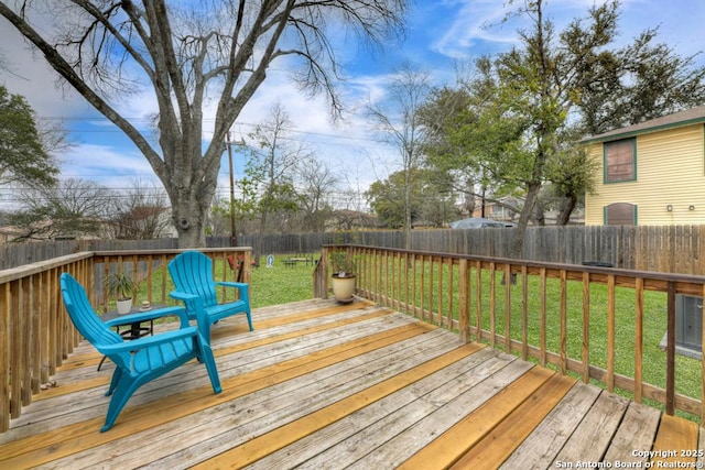 wooden deck featuring a fenced backyard and a yard