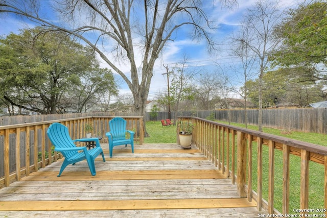 wooden deck featuring a yard and a fenced backyard