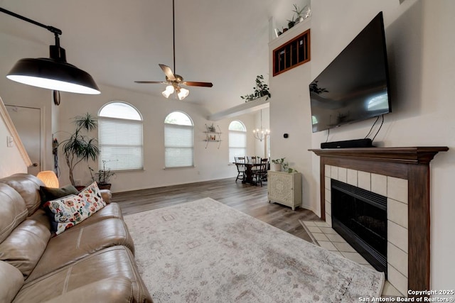 living area featuring a fireplace, a ceiling fan, and wood finished floors