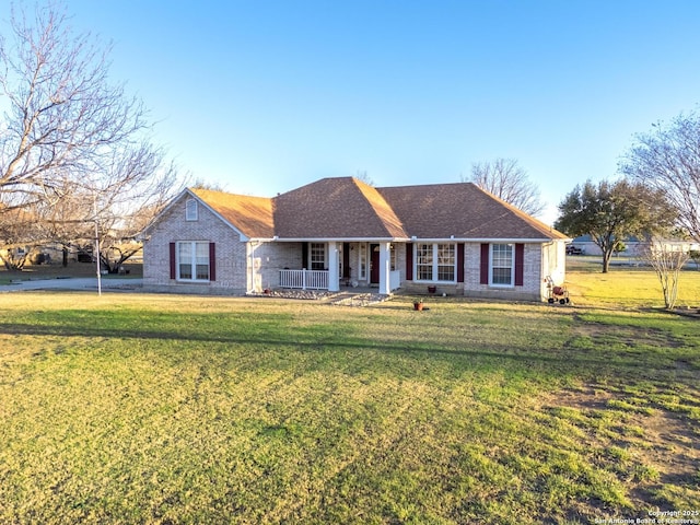 ranch-style house with covered porch, a front lawn, and brick siding