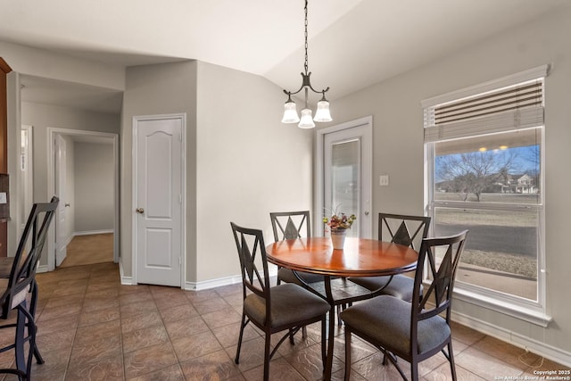 dining room featuring lofted ceiling, a notable chandelier, and baseboards