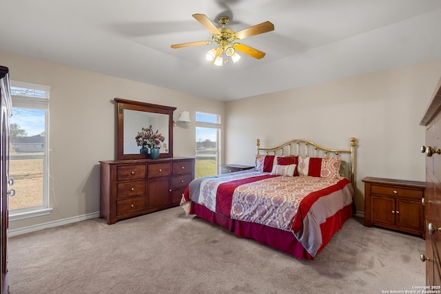 bedroom with baseboards, a ceiling fan, and light colored carpet