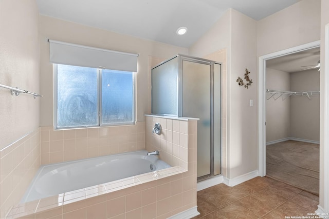 bathroom with a stall shower, a garden tub, a walk in closet, and tile patterned floors