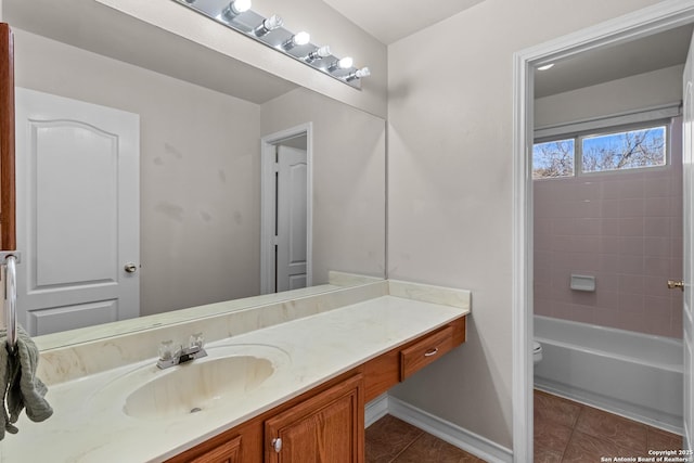 bathroom with toilet, baseboards, vanity, and tile patterned floors