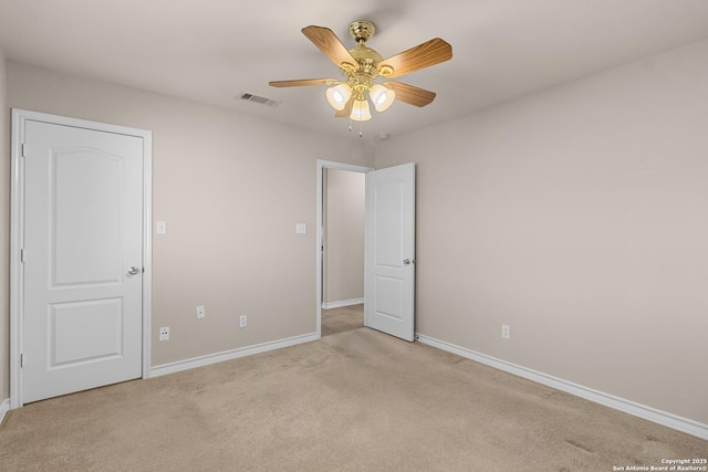 empty room featuring light carpet, visible vents, a ceiling fan, and baseboards