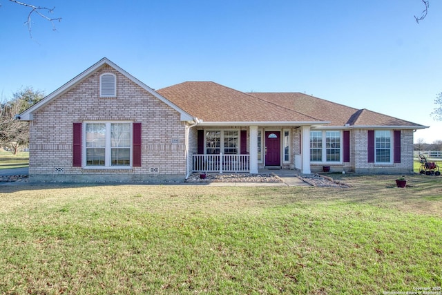 ranch-style house featuring roof with shingles, brick siding, a porch, and a front yard