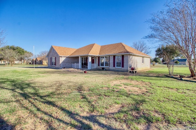 single story home featuring covered porch, a front lawn, and brick siding