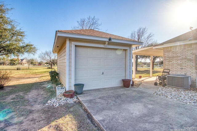 detached garage featuring central air condition unit and concrete driveway