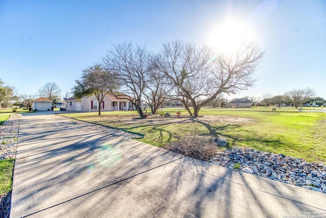 exterior space with a garage, concrete driveway, and a front yard