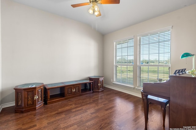 interior space featuring a ceiling fan, lofted ceiling, baseboards, and wood finished floors