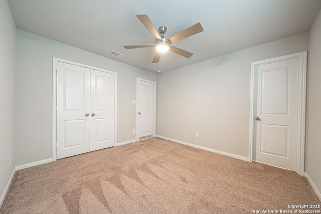 unfurnished bedroom featuring a closet, carpet, visible vents, and baseboards