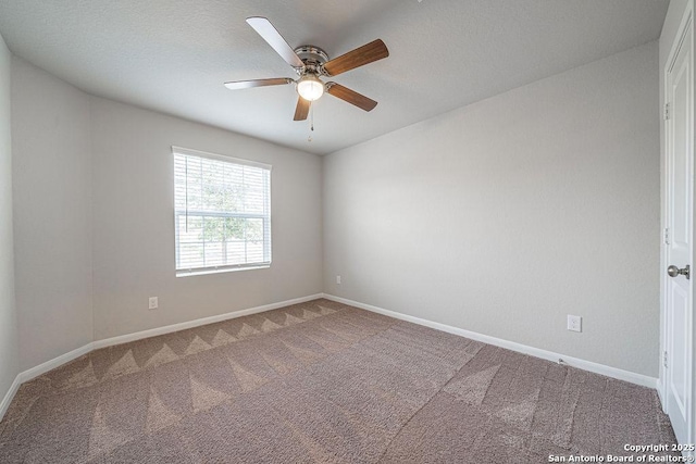 carpeted empty room featuring ceiling fan and baseboards