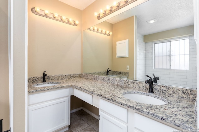 full bath featuring double vanity, tile patterned flooring, and a sink