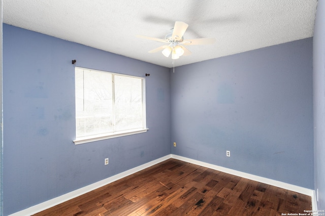 spare room featuring a ceiling fan, a textured ceiling, baseboards, and dark wood-type flooring