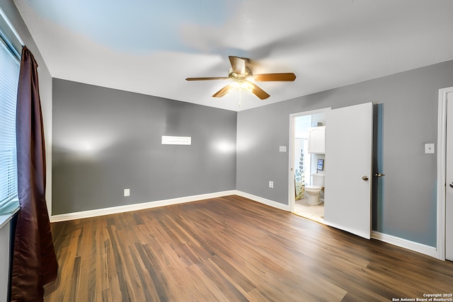 empty room with ceiling fan, dark wood-type flooring, and baseboards