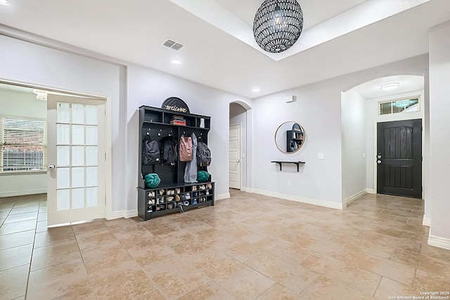 foyer entrance featuring arched walkways, visible vents, baseboards, and recessed lighting