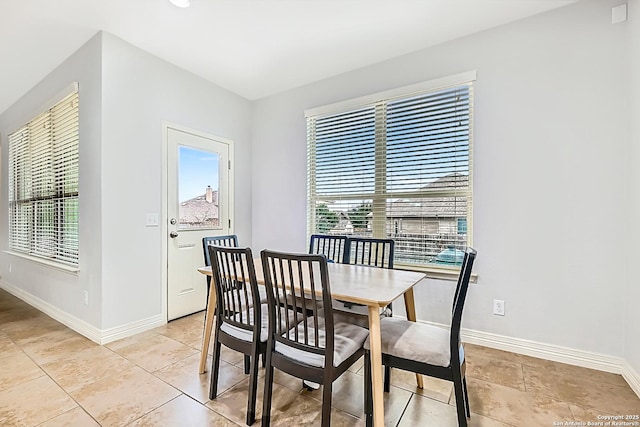 dining room with light tile patterned flooring and baseboards