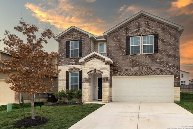 view of front of house featuring an attached garage, brick siding, driveway, stone siding, and a lawn