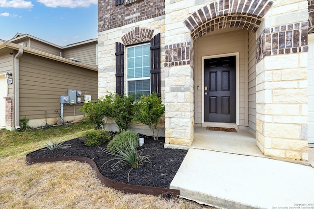 property entrance with stone siding and brick siding