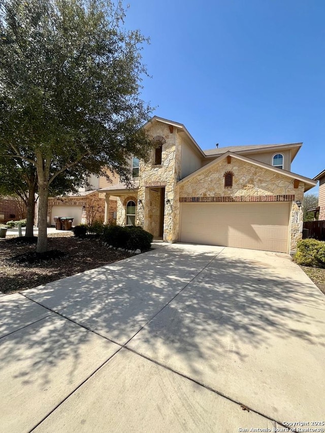 view of front of home featuring a garage, concrete driveway, and stone siding