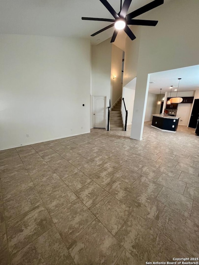 6731 Indian Ldg, San Antonio, TX 78253 - unfurnished living room featuring stairs, a high ceiling, a ceiling fan, and baseboards