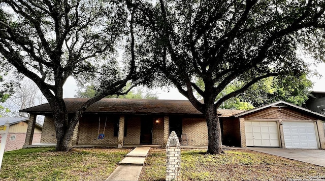 single story home featuring an attached garage, concrete driveway, and brick siding