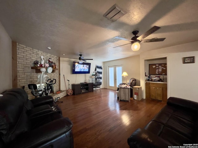 living area featuring visible vents, dark wood finished floors, a textured ceiling, and french doors