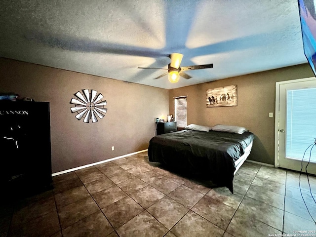 bedroom with a ceiling fan, tile patterned flooring, a textured ceiling, and baseboards