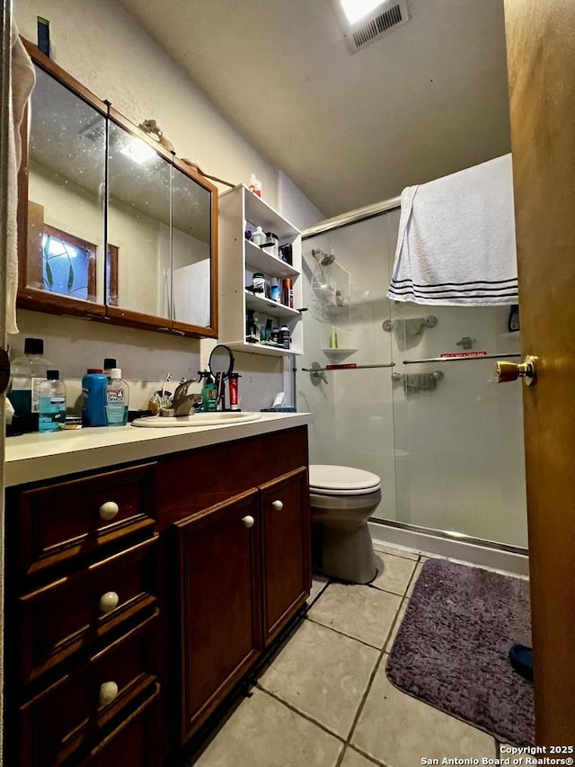 bathroom with tile patterned flooring, toilet, vanity, visible vents, and a stall shower