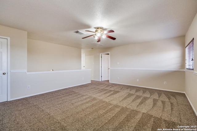 carpeted empty room featuring visible vents, ceiling fan, a textured ceiling, and baseboards