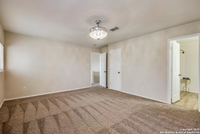 carpeted empty room with visible vents and baseboards