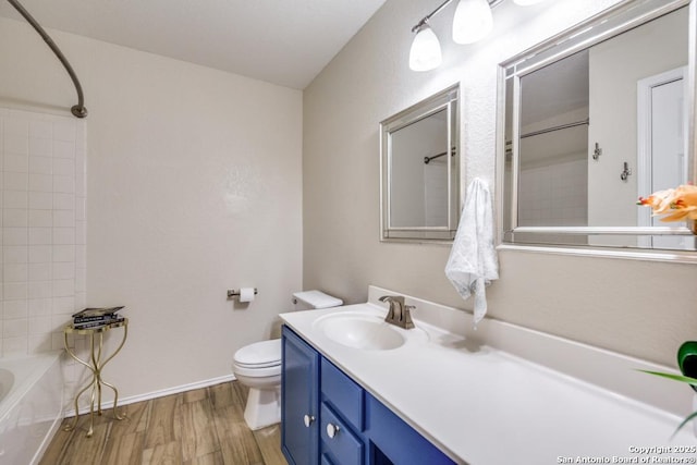 full bathroom featuring bathing tub / shower combination, toilet, vanity, wood finished floors, and baseboards