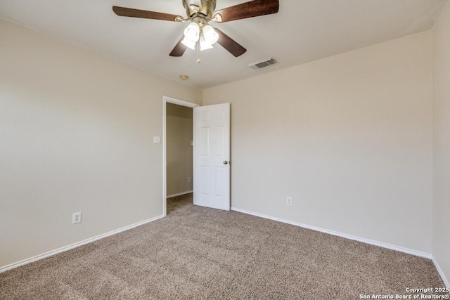 empty room with ceiling fan, carpet flooring, visible vents, and baseboards