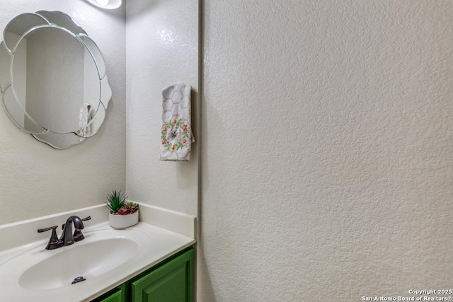 bathroom with a textured wall and vanity