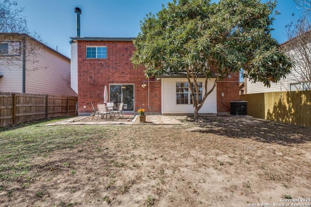 rear view of house featuring a patio area, a fenced backyard, cooling unit, and brick siding