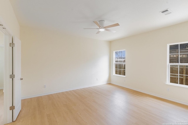 unfurnished room with baseboards, visible vents, ceiling fan, and light wood finished floors