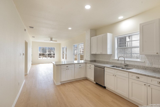 kitchen with tasteful backsplash, visible vents, dishwasher, a peninsula, and a sink