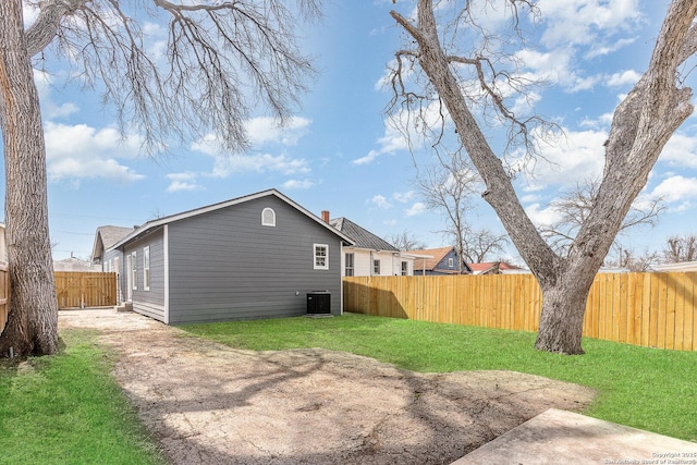 exterior space featuring a fenced backyard, a yard, and central air condition unit