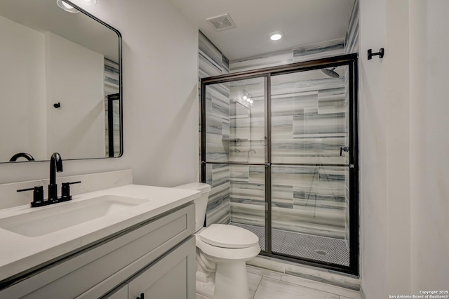 full bathroom featuring toilet, a stall shower, vanity, and visible vents