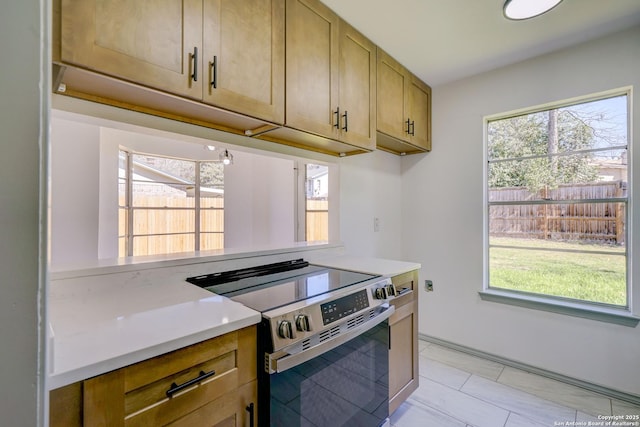 kitchen with plenty of natural light, stainless steel electric range, and light countertops