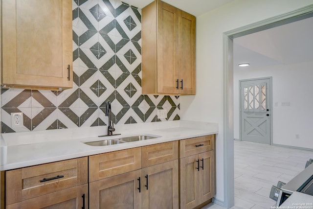 kitchen featuring backsplash, a sink, and light countertops