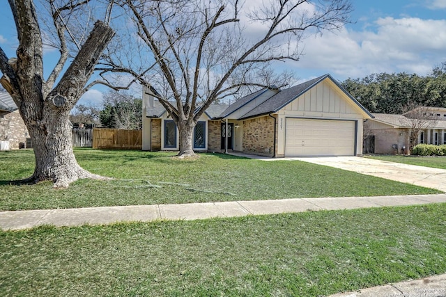 view of front of property featuring an attached garage, brick siding, fence, a front lawn, and board and batten siding